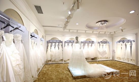 PART1.婚纱店装修技巧: 若想成功经营一家婚纱店,那么除了要选对婚纱礼服外,店铺的装修风格也至关重要。现在青岛装修网就来给大家讲讲如何将店铺装修得时尚大气,以增加准新娘的购买信心。 1.先从色调入手 例如主调以透明感比较强的乔其纱白为主,那么中间用紫色与黑色相配,让人感觉透露出一种神秘的美感。许多婚纱店都是把自己店堂的颜色定为单纯的白色。其实,这是一种简单的敷衍。其实白色有很多调子:冷冷的清白,暖暖的粉白,柔和的象牙白,睿智的米白,略带古朴的漂白,透明感很强的乔其纱白。但是,更多的店面设计师不是非常